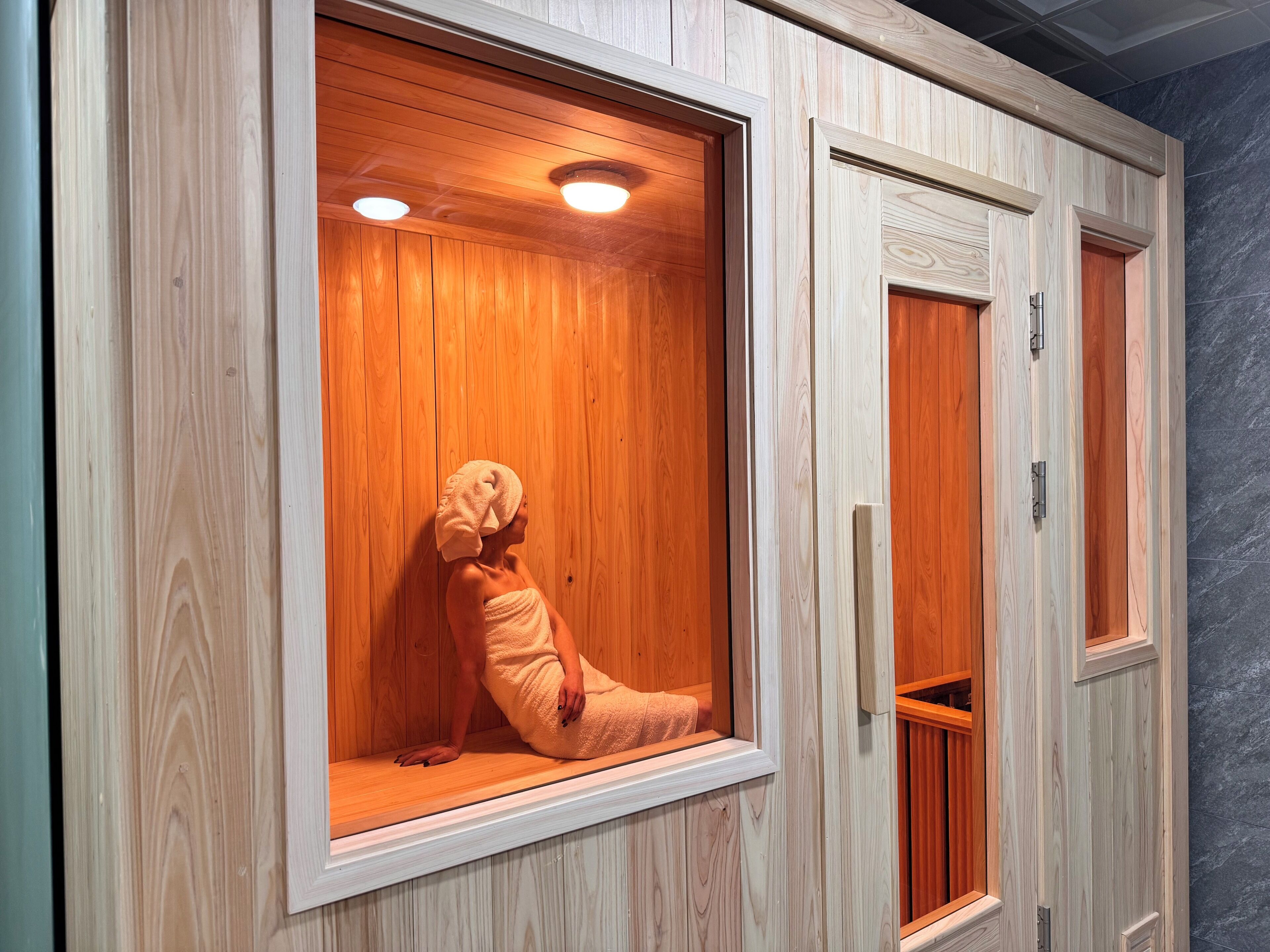 A sauna room with wooden walls and a bench.