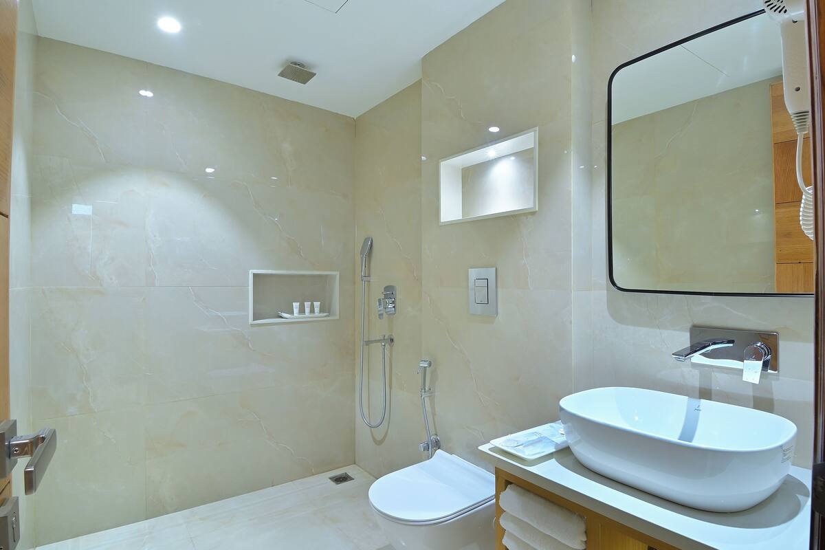 Un bany modern amb un lavabo gran, un mirall i una dutxa.
