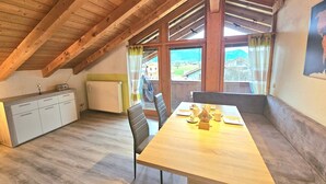 Ein Essbereich mit Holztisch, Stühlen und Blick ins Freie.