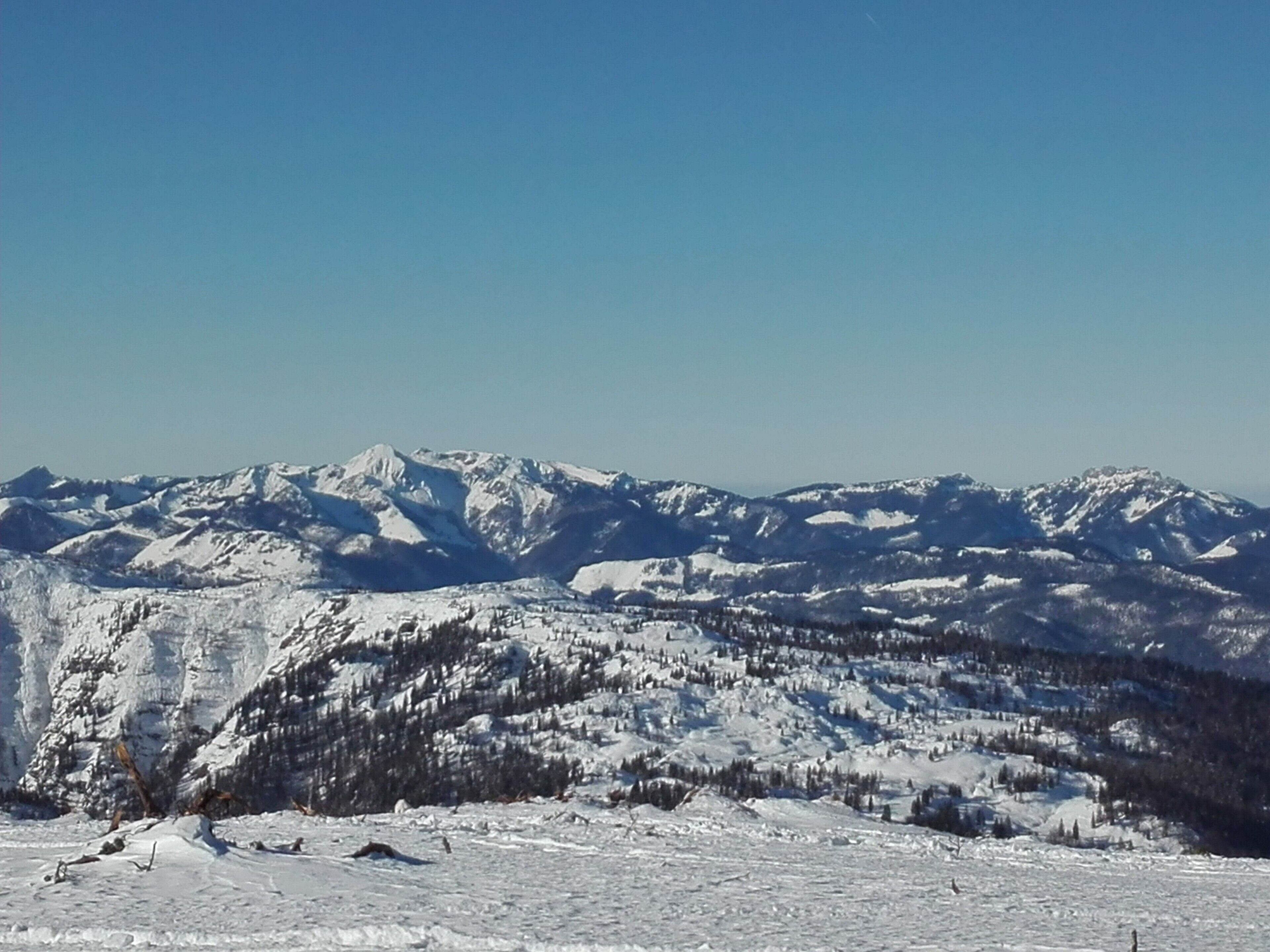 A snow-covered mountain landscape with clear skies.