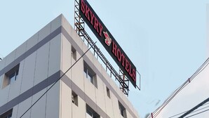 Un immeuble hôtelier à plusieurs étages, sur lequel on peut voir une enseigne bien visible indiquant « SKYRY HOTELS ».