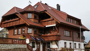A traditional wooden house with multiple balconies, a stone staircase, and a wooden fence. - Apartment 'Steinbühlschlössle' with Shared Terrace, Shared Garden and Wi-Fi (Schönwald im Schwarzwald)