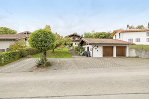 En boligvej med huse, en belagt indkørsel og et træ.