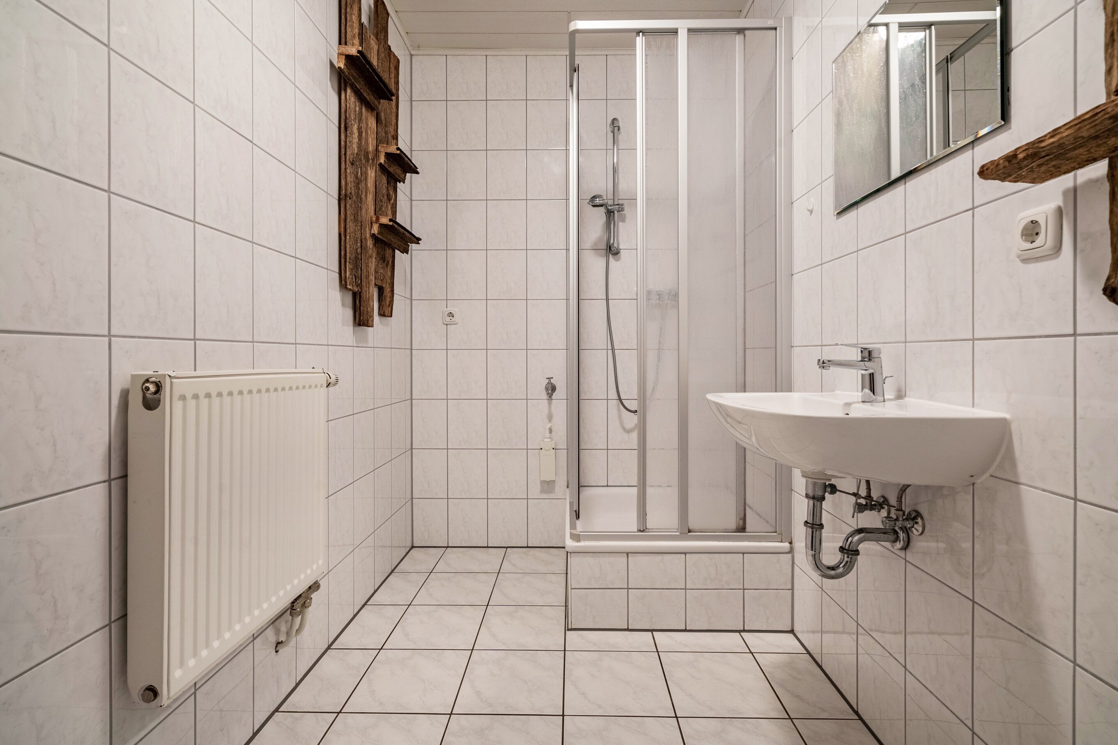 Ein Badezimmer mit Dusche, Waschbecken und Spiegel.
