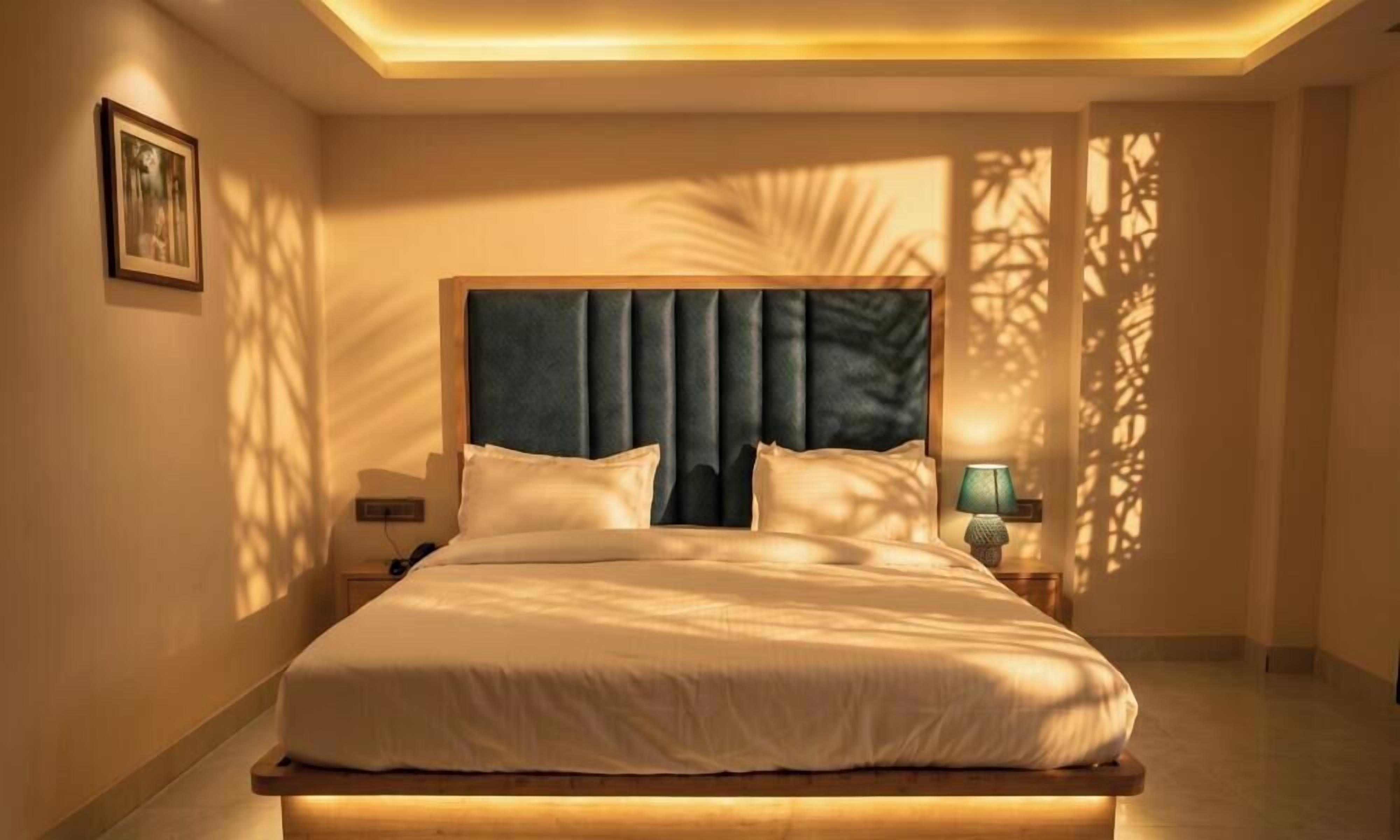Une chambre à coucher moderne avec un grand lit, des lampes de chevet et un luminaire au plafond.