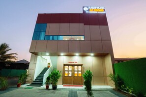 A modern building with a sign for Aditva Inn AC Rooms and a Banquet Hall entrance. - Itsy Hotels Aaditya Inn Tathawade (Paud)