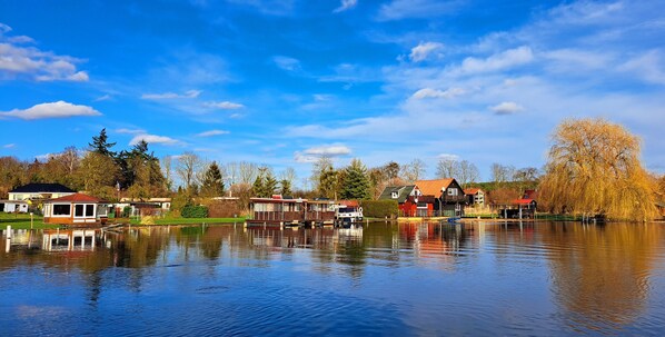 Una propiedad junto al lago con varias casas, un muelle y cielo despejado.