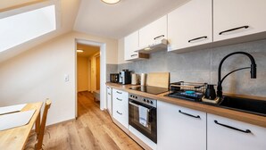 Una cocina moderna con gabinetes blancos, un grifo negro y una encimera de madera.