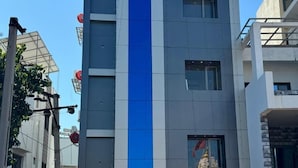 En modern hotellbyggnad med det tydligt synliga namnet ”HOTEL KRISHA”.