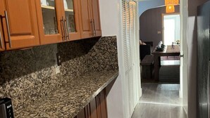 Una cocina con armarios de madera, encimeras de granito y vistas al área de comedor.