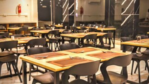 A restaurant with multiple tables and chairs, arranged in a spacious layout.