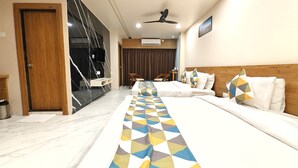 A hotel room with a long bed, a wooden headboard, and a ceiling fan.
