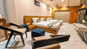 A modern hotel room with a wooden bed, two blue armchairs, a wooden nightstand, and a marble floor.