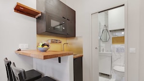 A compact kitchen with a microwave, a small sink, and a wooden countertop. - Cozy studio - 2P - Gare de l'Est (Paris)