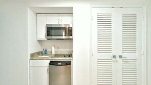 A compact kitchen with white cabinets, a stainless steel microwave, a dishwasher, and a double door closet. - W Hotel SOUTH BEACH 1B RESIDENCE w/OCEAN VIEW - 909 (Key Biscayne Miami)
