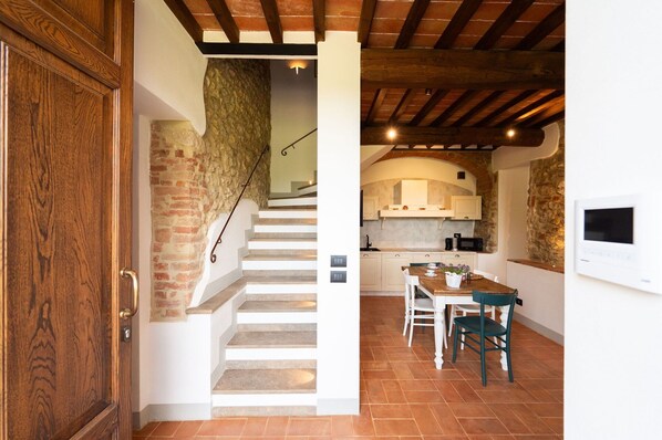 A staircase leading to a kitchen with a dining area.