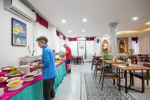 Un espace repas avec des tables, des chaises et un buffet.
