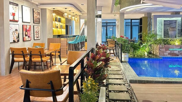 Espaço de piscina interior moderno com assentos e vista para a piscina.