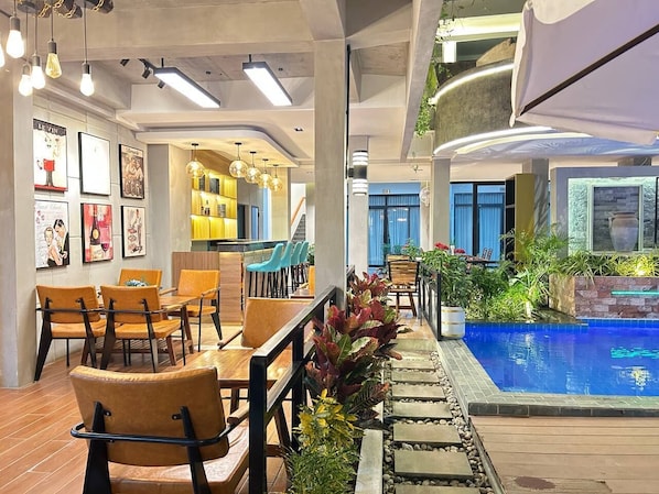 A modern indoor pool area with seating and a view of the pool.