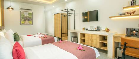 A hotel room with two beds, a desk, a TV, and a ceiling fan.