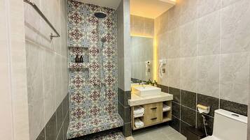 Een badkamer met een douche, wastafel, toilet en een badkamermeubel met handdoeken.