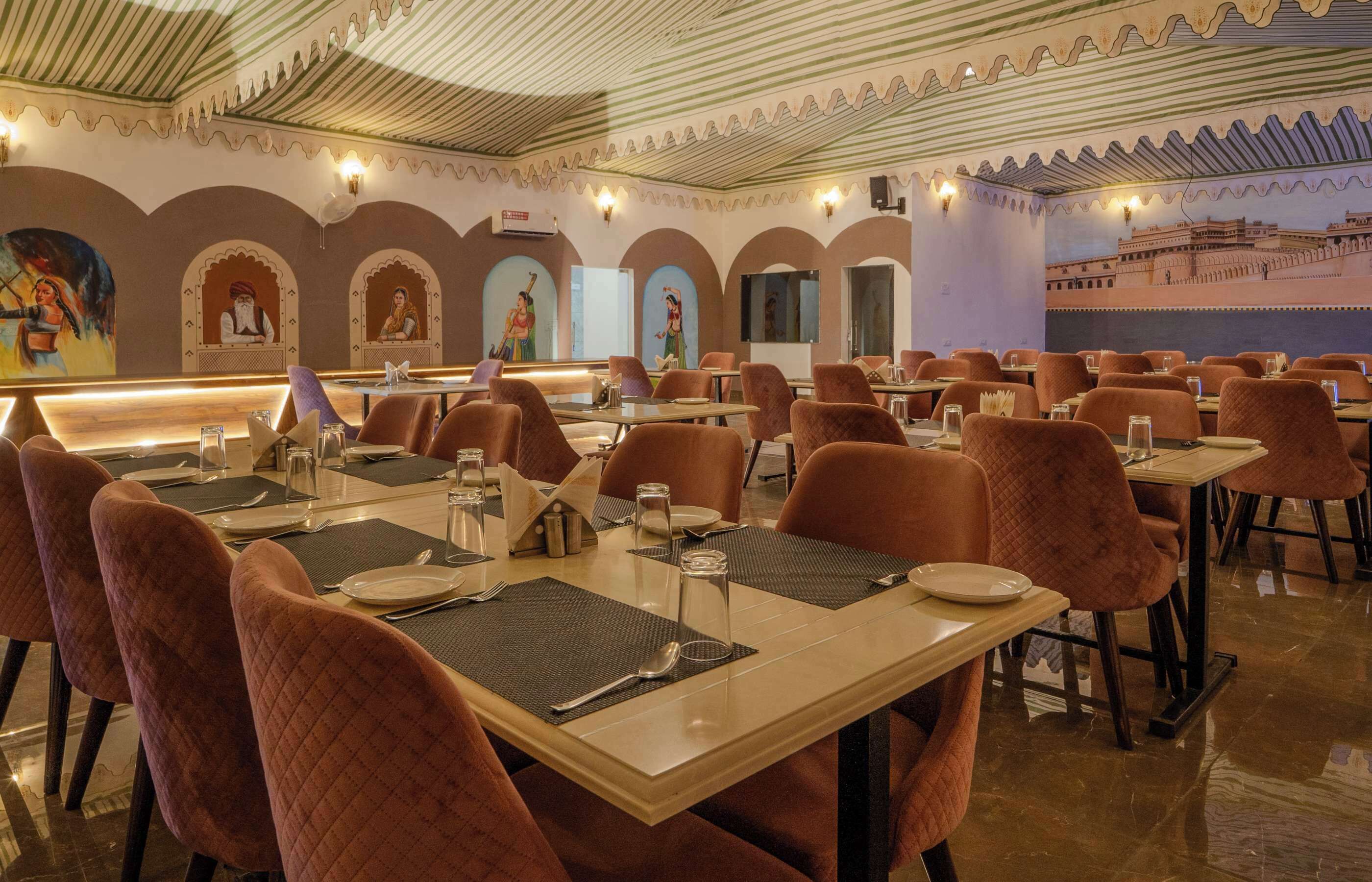 A restaurant with multiple tables and chairs, each set with cutlery and glasses.