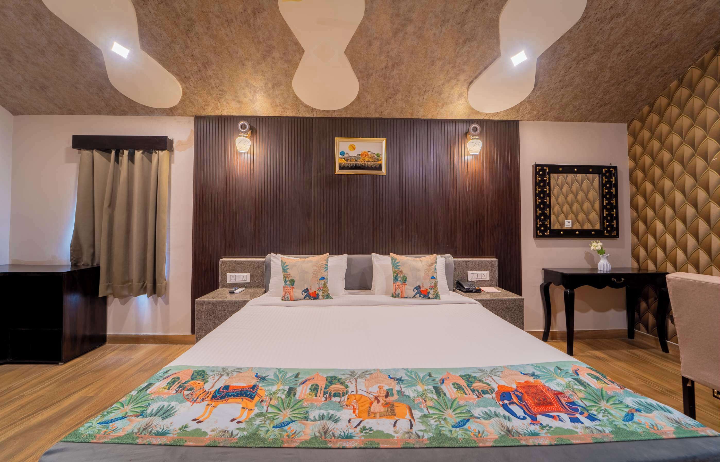 A hotel room with a large bed, wooden headboard, two bedside tables, a nightstand, a decorative rug, and a wall-mounted picture.