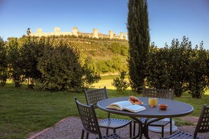 An outdoor seating area with a table, chairs, and a book. - Nice apartment for 2 people with pool, A/C, WIFI, TV and pets allowed, close to Siena (Monteriggioni)