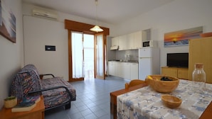 A compact living space with a kitchenette, a dining area, and a sofa set. - Delightful studio in the town center (Bibione)