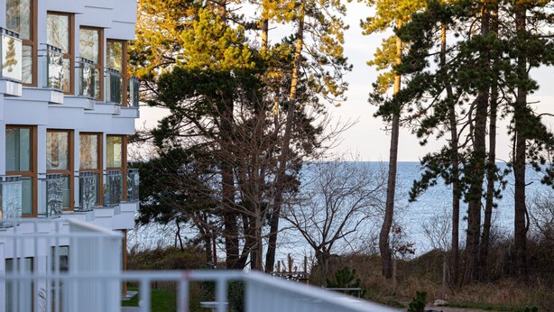 Um edifício moderno com amplas janelas e vista para o mar.