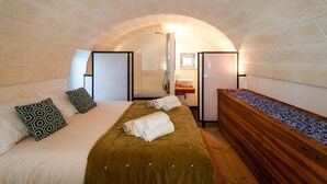 Una habitación acogedora con cama, cómoda de madera, lavamanos y toallero.