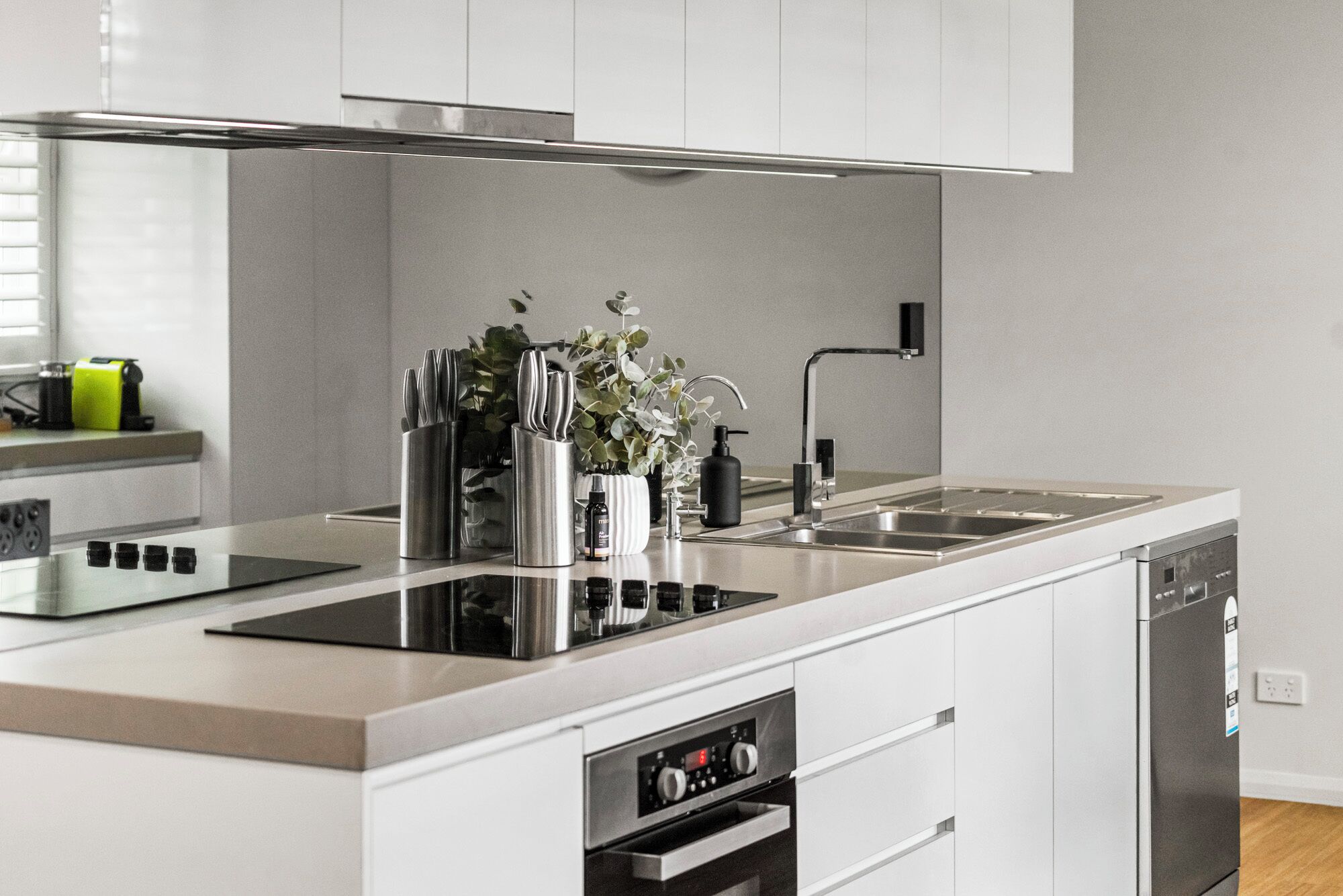 A modern kitchen with a built-in dishwasher, stainless steel appliances, and a minimalist design.
