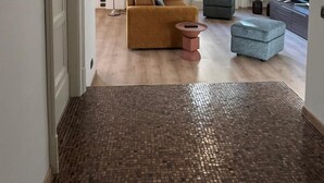 A spacious living room with a large sofa, a small ottoman, and a floor lamp. - Casa Degli Aranci Charming apartment in the prestigious neighborhood of Vomero (Napoli)
