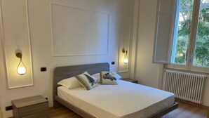 A modern bedroom with a wooden bed, white walls, and two bedside tables. - Casa Degli Aranci Charming apartment in the prestigious neighborhood of Vomero (Napoli)
