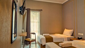 A hotel room with two beds, a chair, a small table, and a mirror. - WAKAYAPA Syariah Residence (Kelapa Dua)
