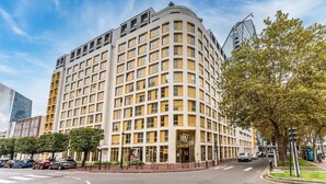 A multi-story hotel with a yellow facade, large windows, and a prominent entrance.