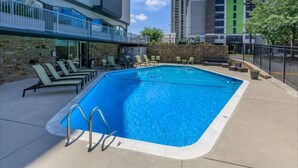A swimming pool with lounge chairs and a stone wall, surrounded by a fence. - Cozy 1-bedroom condo with AC, WiFi in welcoming Towson (Towson)