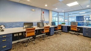 A modern office with multiple workstations, large windows offering a view of the sea, and a sailboat decoration on the wall. - Cozy 1-bedroom condo with AC, WiFi in welcoming Towson (Towson)