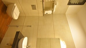 A bathroom with a toilet, sink, and shower area. - Hotel 7b (Chhatarpur)
