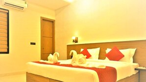 A hotel room with a wooden bed frame, a red and white bedspread, and decorative swan pillows. - Hotel 7b (Chhatarpur)