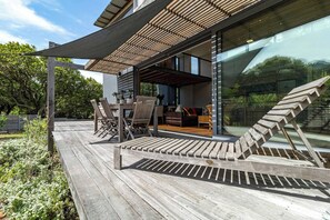 A wooden deck with outdoor furniture, a pergola, and a glass wall reflecting the surrounding greenery. - Luxury Eco Villa, Hout Bay, Cape Town,south Africa (Cape Town)