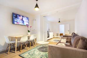Relax in this stylish living space with a flat-screen TV, dining area, and cozy seating area.