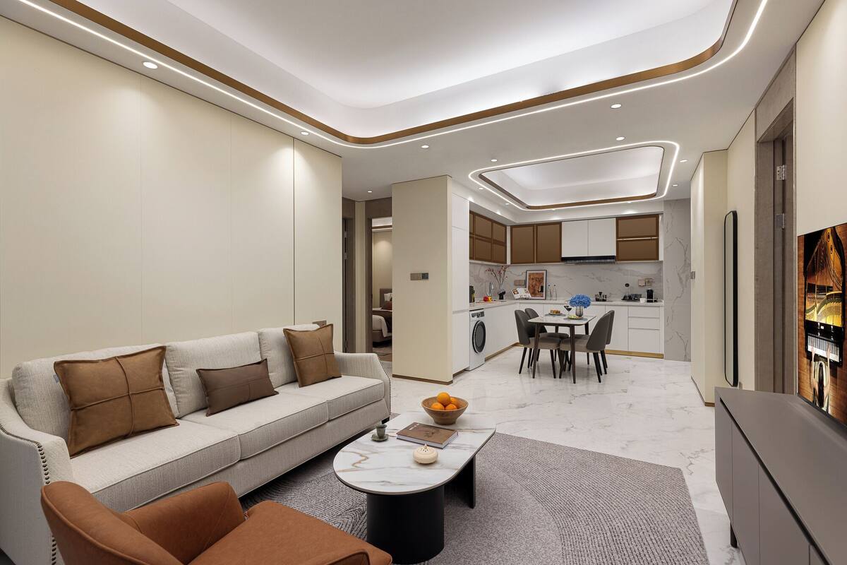 Een moderne woonkamer met een bank, salontafel en stoelen. Er is een keuken met kasten en een eettafel.