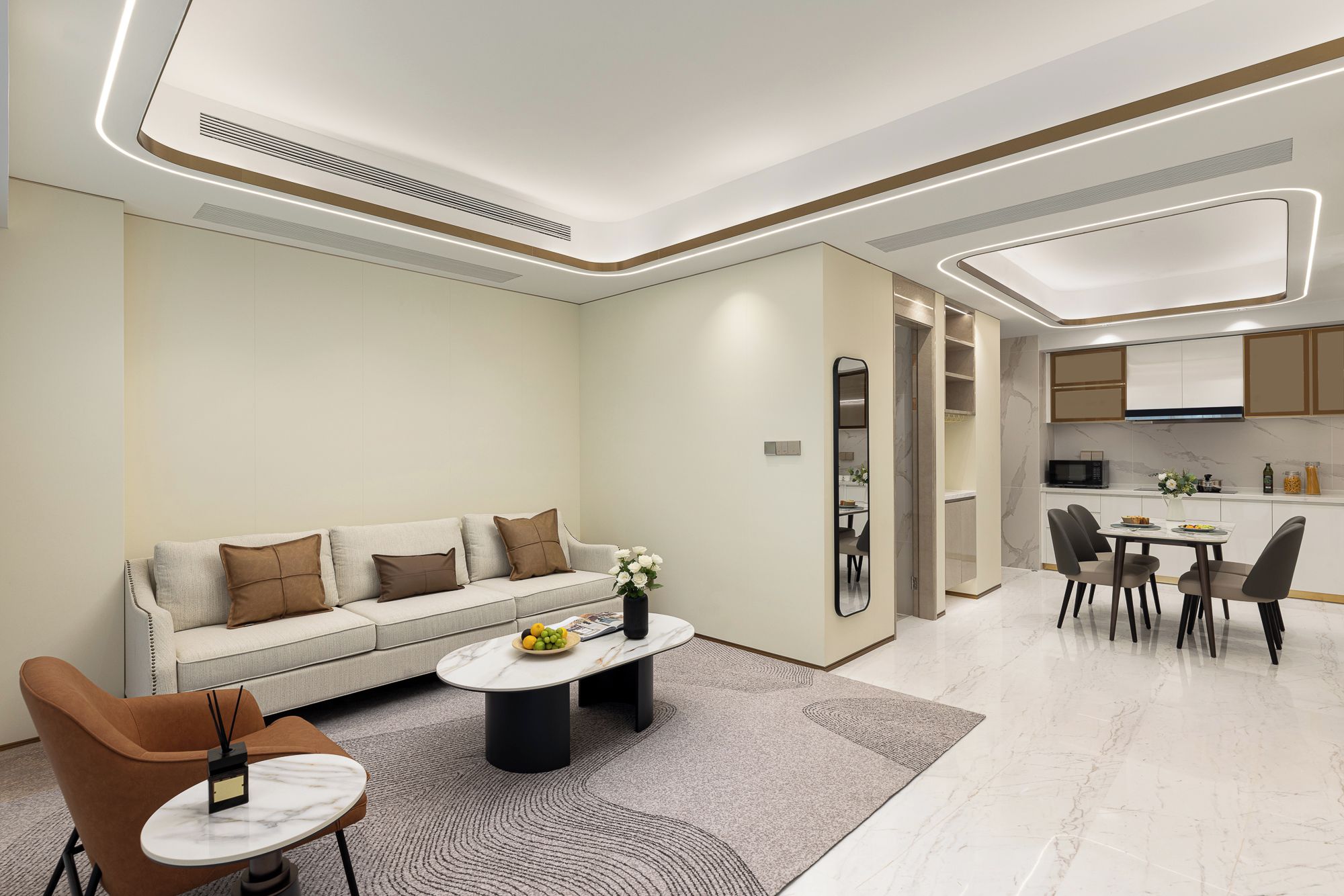 A modern living room with a sofa, coffee table, and chairs. A kitchen is visible in the background with a dining table and chairs.