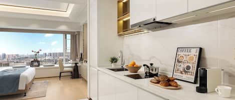 A modern kitchen with a city view, a dining area with a table and chairs, and a bed with a view.