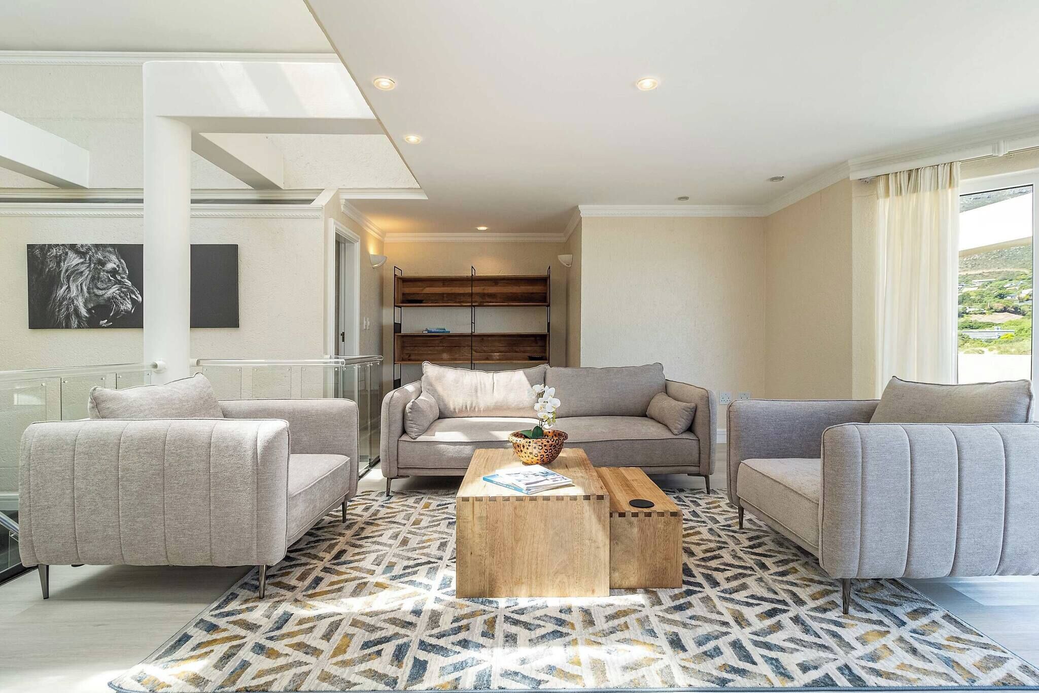 A modern living room with a sofa set, a coffee table, and a patterned rug.