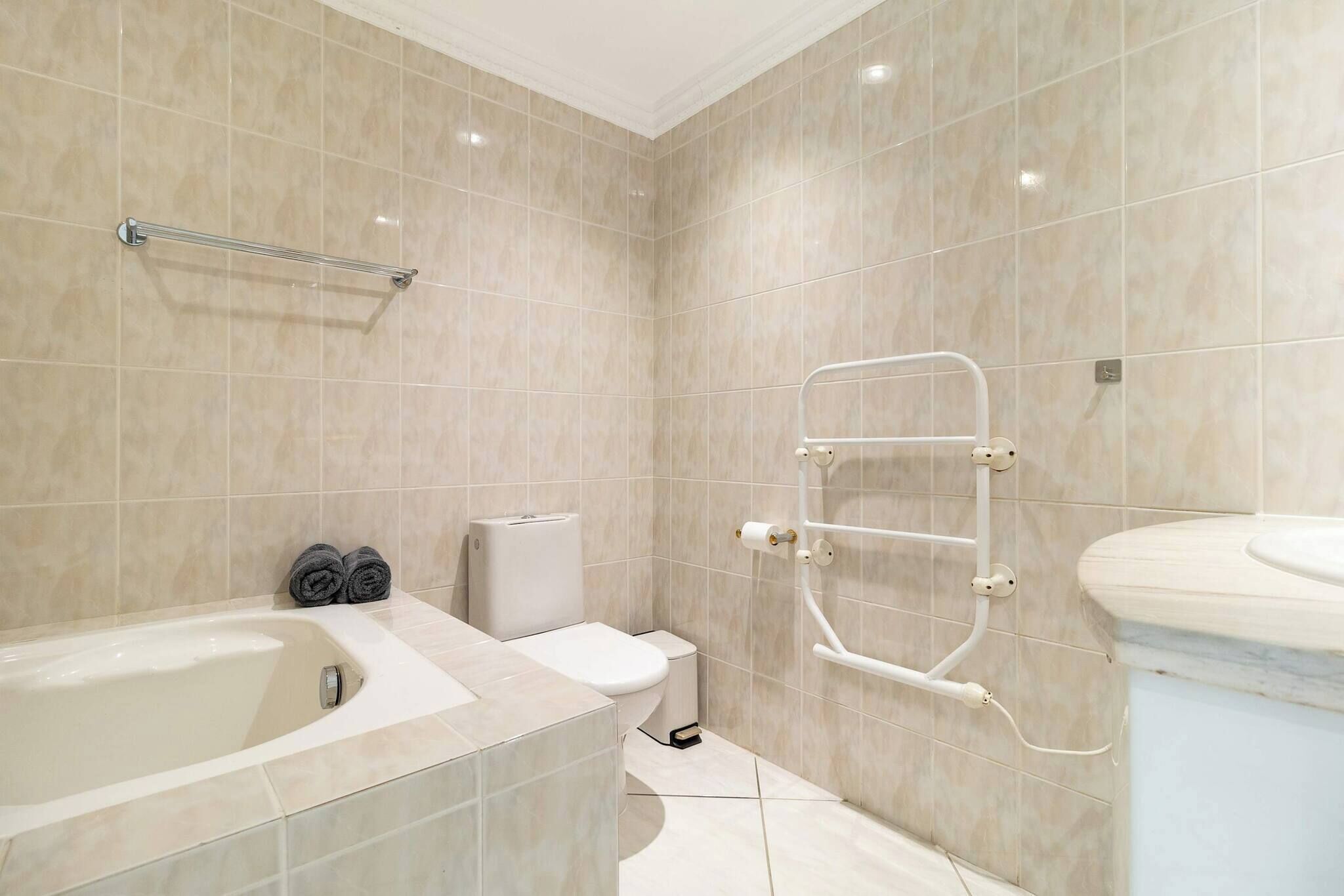 Une salle de bain moderne équipée d’une baignoire, de toilettes et d’un espace douche.