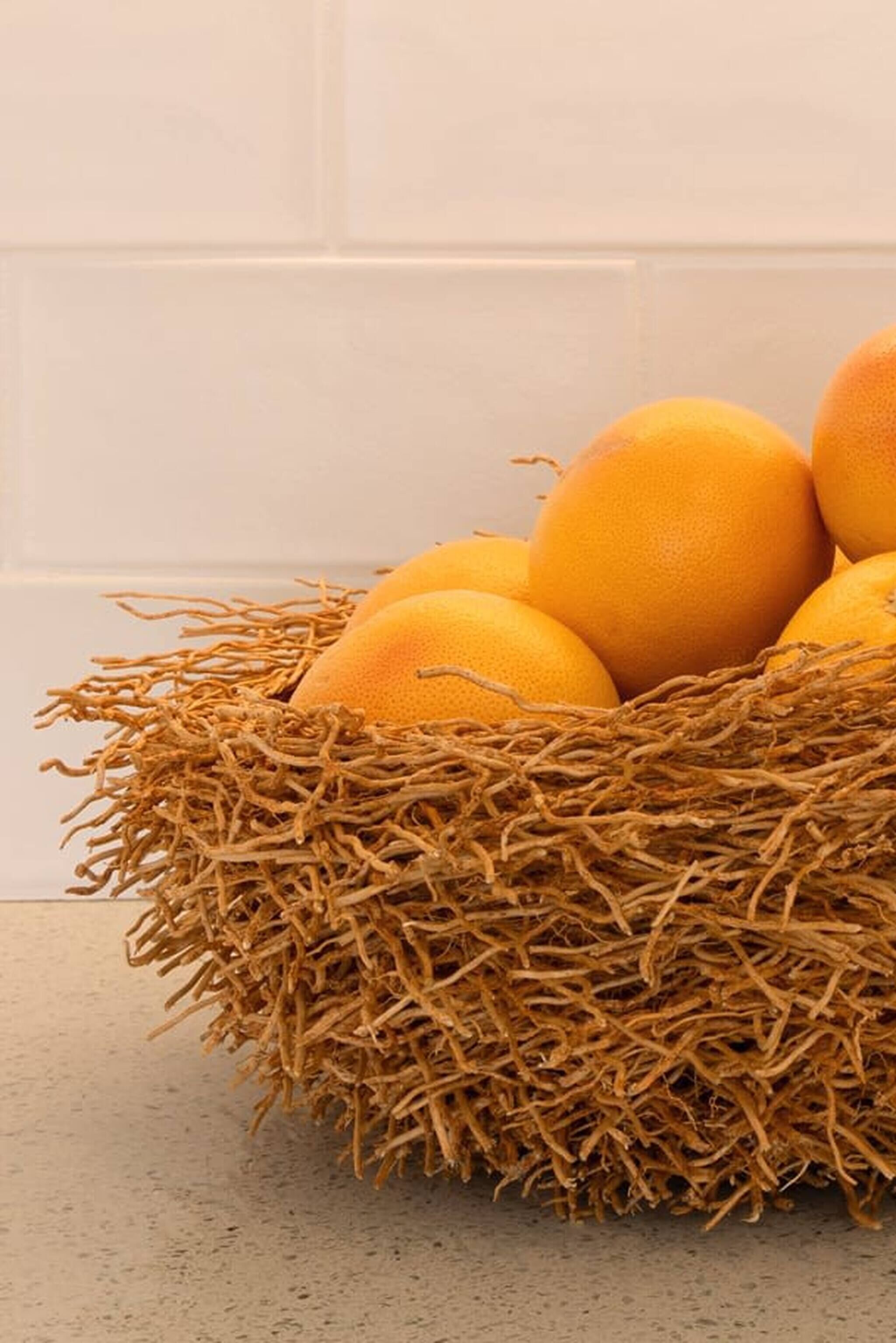 Una cesta de naranjas sobre una encimera.