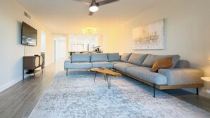 A modern living room with a sectional sofa, a coffee table, and a flat-screen TV. - Welcome to Your Luxurious Golf Getaway! (Fort Myers)