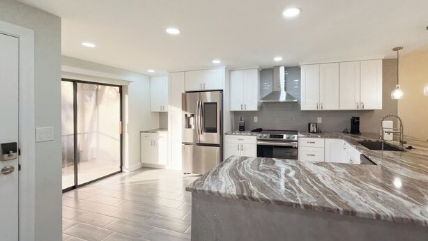 A modern kitchen with white cabinets, stainless steel appliances, and a marble countertop. - Welcome to Your Luxurious Golf Getaway! (Fort Myers)